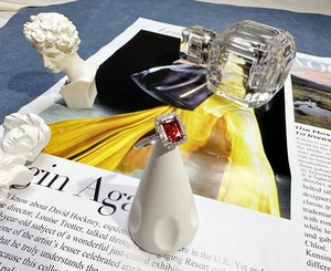 Detail shot of rectangular emerald-cut red ruby ring on a premium jewelry display