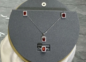 Detailed set of silver jewelry featuring rectangular ruby stones and zircon halos