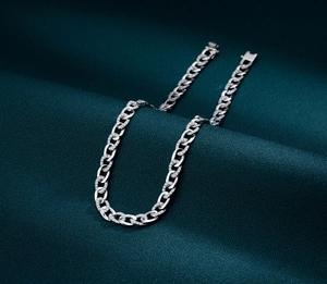 Macro detail of silver Cuban link chain with micro-pave diamonds and insertion clasp