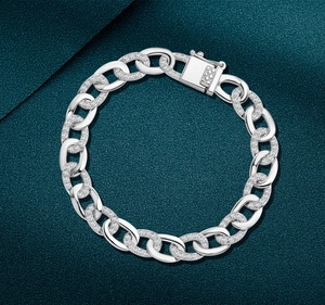 Close-up of silver Cuban link bracelet with pavé-set stones and secure box clasp