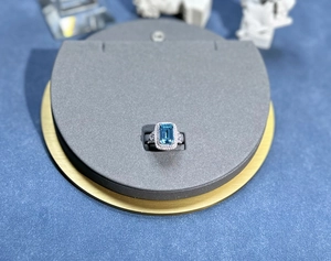 Macro shot of rectangular aquamarine ring with pavé diamond halo on silver setting