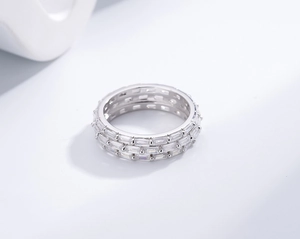 Macro detail of silver eternity ring featuring three rows of rectangular cubic zirconia stones