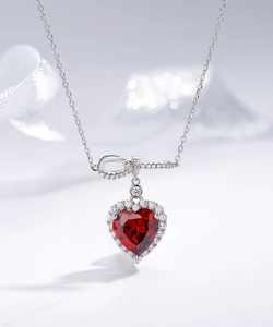 Macro d'un collier en argent 925 avec pierre de cœur rouge et détail de nœud