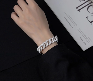 Dettaglio del bracciale a catena cubana in argento con pavé di diamanti indossato al polso