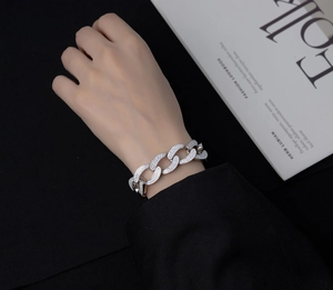 Macro shot of silver cuban link bracelet with pave cubic zirconia on a wrist