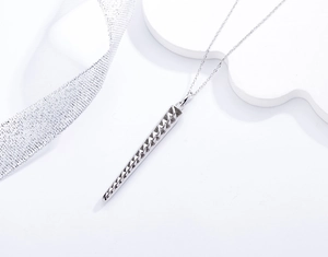 Macro detail of S925 silver cone pendant with geometric diamond pattern and cross chain