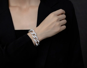 Close-up of silver Cuban link bracelet with pavé cubic zirconia on a black suit sleeve