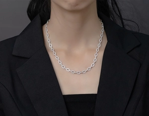 Macro detail of silver Cuban link necklace with micro-pave diamonds on a male model