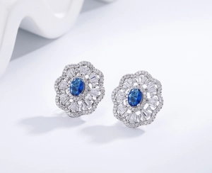 Macro shot of oval sapphire-blue stud earrings with halo micro-pave crystal details