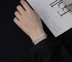 Close-up of silver Cuban chain bracelet with micro-paved white zircons on wrist