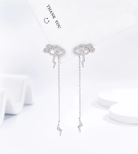 Macro detail of silver cloud and lightning drop earrings with cubic zirconia tassels