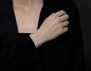 Macro shot of silver Cuban link bracelet featuring micro-pave cubic zirconia on black sleeve