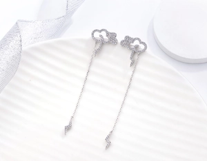 Detail of silver cloud and lightning tassel earrings with micro-paved cubic zirconia