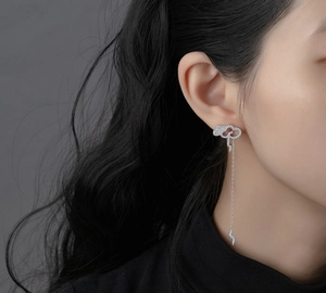 Detail of sterling silver cloud and lightning tassel earrings with micro-paved diamonds