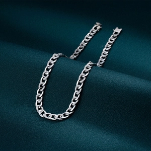 Silver Cuban link necklace with micro-pave diamonds on dark textured fabric background