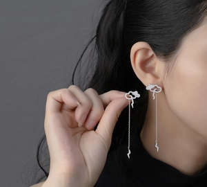 Macro detail of silver cloud lightning tassel earring with pavé diamonds on a model
