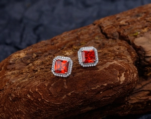 Vue macro de boucles d'oreilles carrées en argent avec micro-pavé et rubis rouge