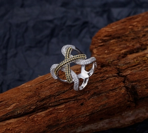 Macro detail of S925 sterling silver cross ring with pavé micro-set diamonds on wood texture