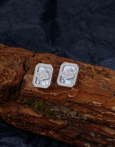 Macro detail of silver square stud earrings with mother of pearl and star zircons