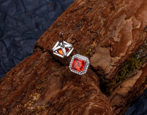 Vue macro de boucles d'oreilles en argent 925 avec rubis orange coupe princesse