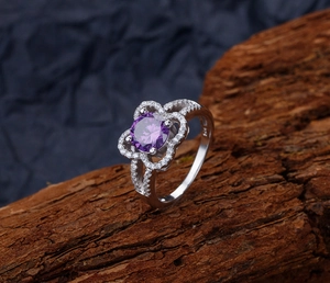 Detailed close-up of S925 hallmark on silver flower ring with purple zircon stone