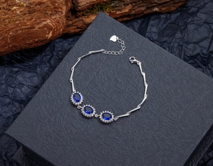 Macro detail of S925 silver bracelet featuring oval blue sapphires and fine zircon halo