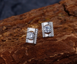 Vue macro de boucles d'oreilles géométriques en argent avec diamants étincelants