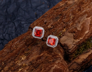 Vue macro de boucles d'oreilles rubis en argent 925 avec halo sur écorce moussue