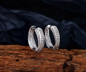 Macro shot of silver S925 Mobius hoop earrings with three rows of pavé diamonds