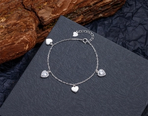 Détail d'un bracelet en argent avec cœurs pavés scintillants et cœurs en métal poli