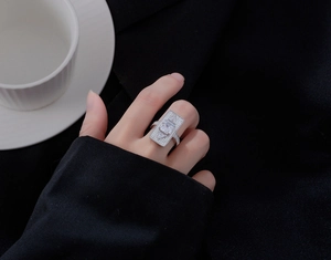 Primo piano di un anello rettangolare in argento con micro-pavé di diamanti sulla mano