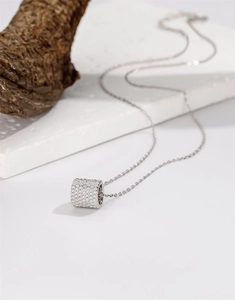 Macro shot of silver cylinder pendant necklace with sparkling micro-paved cubic zirconia