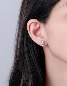 Gros plan d'une boucle d'oreille rectangulaire en argent sertie de diamants sur un mannequin