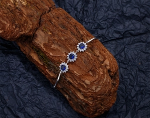 Détail du bracelet tournesol bleu avec zircons saphir sur une écorce de bois