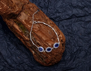 Close-up of S925 silver bracelet featuring blue sapphire gems and bamboo link chain