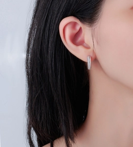 Close-up of S925 sterling silver Mobius earrings with micro-pave crystals on a model