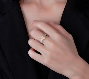 Detailed view of an oval yellow gemstone ring with marquise accents on female finger