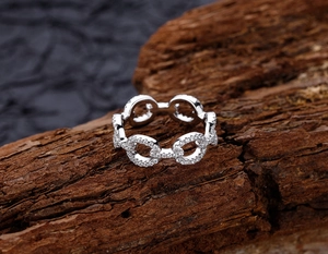Macro shot of S925 sterling silver chain ring with pavé diamonds on tree bark