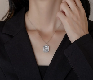 Detail of silver S925 necklace with mother of pearl and zircon stones on female model