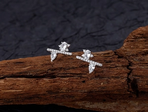 Macro detail of S925 silver irregular stud earrings with cubic zirconia on natural bark