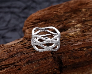 Macro shot of 925 sterling silver wide band ring with wave lines and pavé zircons