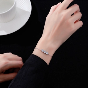 Détail du bracelet en argent S925 avec trois zircons clairs porté sur le poignet