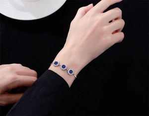 Détail du bracelet tournesol en argent 925 avec saphir bleu de 6 mm porté au poignet