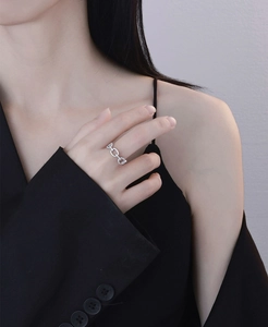 Macro shot of silver chain ring with micro-paved zircons worn on female finger