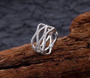 Close-up of S925 silver layered ring with micro-pave white zircon on natural bark background