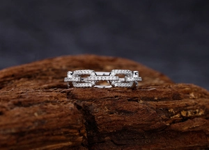Macro view of silver chain ring with micro-pave diamonds on natural wood background