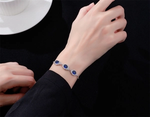 Gros plan d'un bracelet en argent 925 avec saphirs bleus ovales et cristaux étincelants micro-pavé
