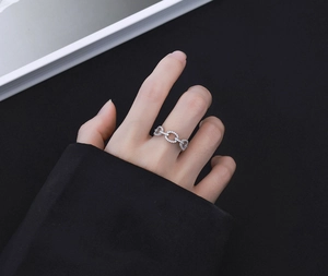 Detail of S925 silver chain ring with pavé cubic zirconia worn on middle finger