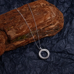 Silver Mobius pendant necklace with pave diamonds on wood texture and blue background