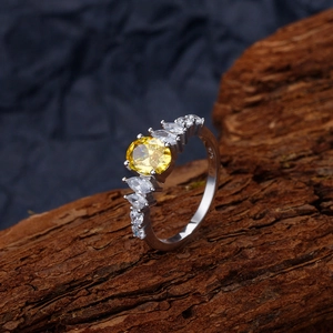 Elegant 925 sterling silver ring featuring an oval yellow gemstone on dark wood background